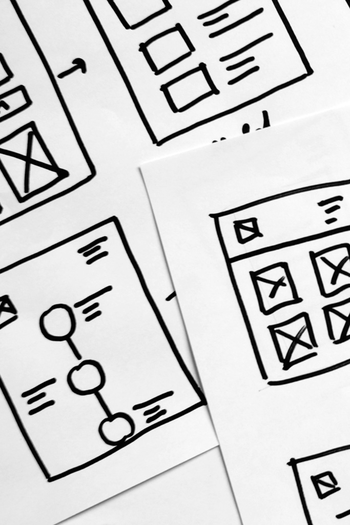 Close-up of user interface wireframe diagrams drawn on paper.