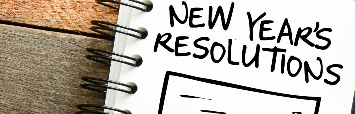 Notebook with "New Year's Resolutions" written on a page, spiral binding visible.